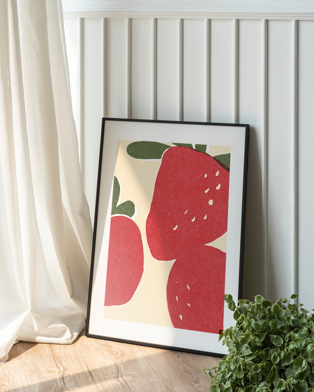 Framed strawberry artwork near window