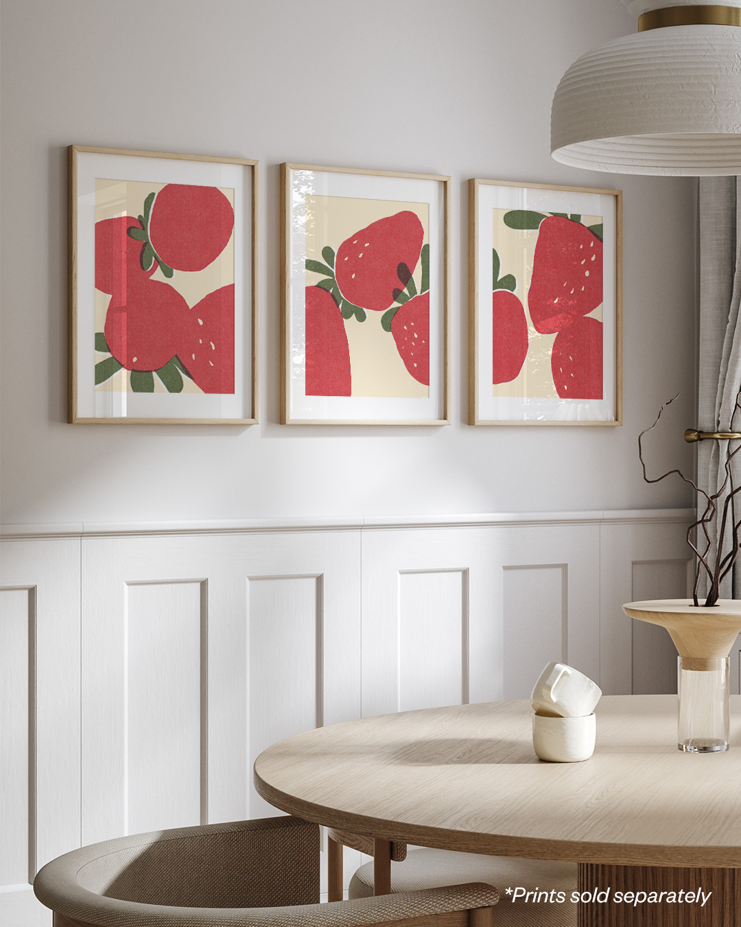 Gallery wall with three framed strawberry prints in a white interior